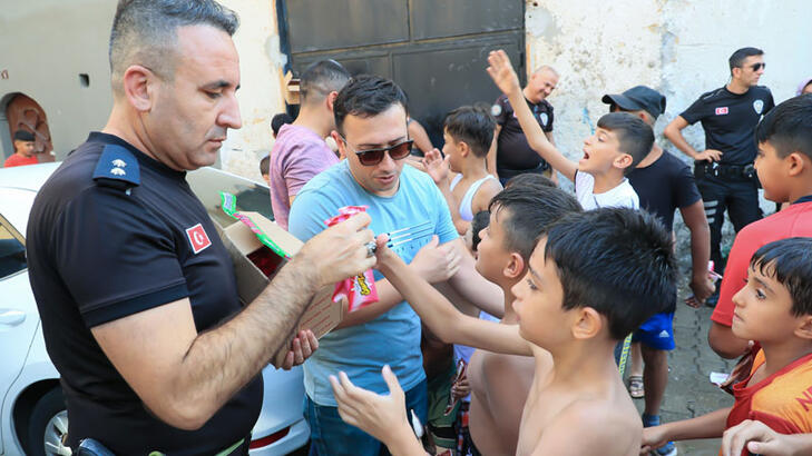 Sıcaktan bunalıp süs havuzunda serinleyen çocuklara polisten dondurma sürprizi